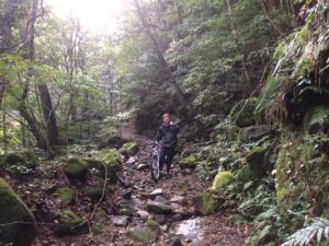 a cyclist riding on mountain trails in Japan