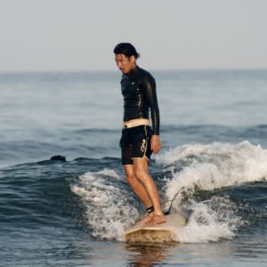 a man standing on a surf board from a surfing lesson in Miyazaki