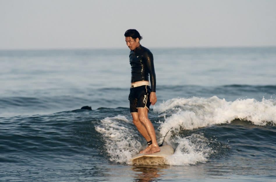 a man standing on a surf board from a surfing lesson in Miyazaki