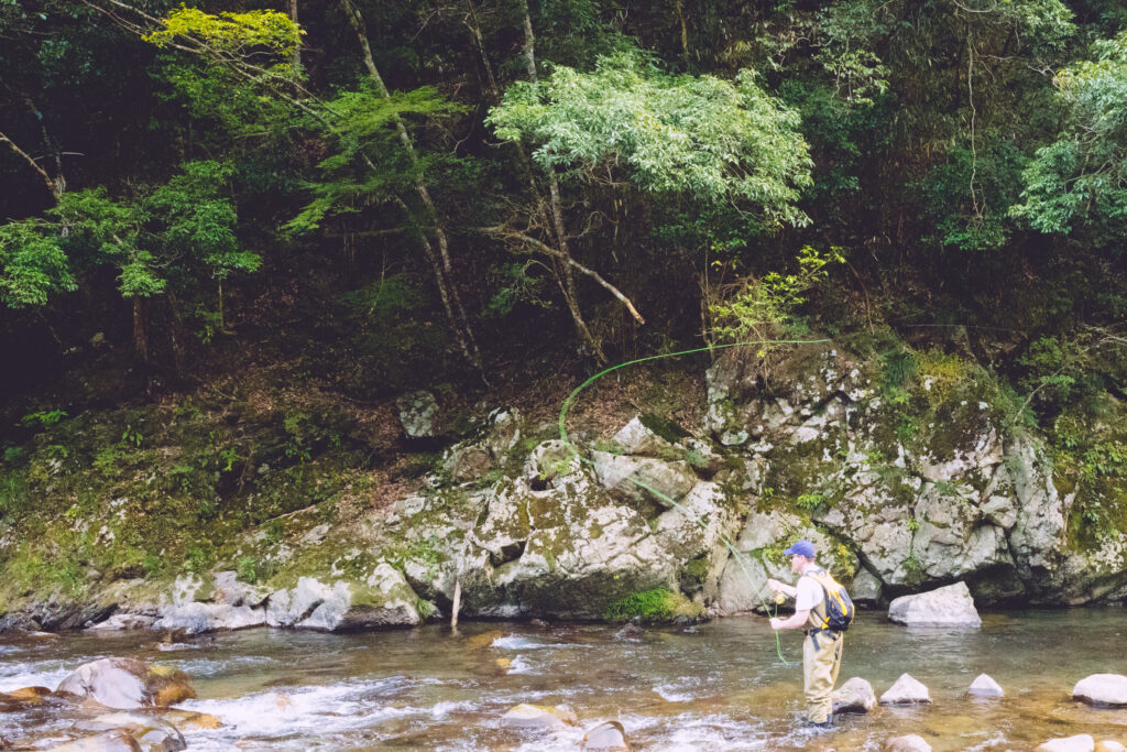 a man casting a fly rod for Trout in Japan