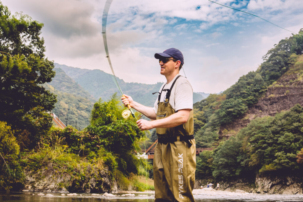 Man casting into river in Japan for troit using fly rod